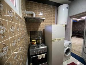 a kitchen with a stove and a refrigerator at Apartment Registan in Samarkand