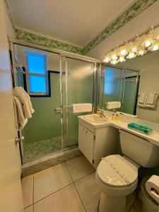 ein Bad mit einer Dusche, einem WC und einem Waschbecken in der Unterkunft The Grove Beach Condominiums in Delray Beach