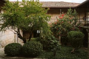 a yard with trees and bushes in front of a house at Casa Rural Rectoral de Armariz in Nogueira de Ramuin