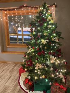 Un árbol de Navidad con regalos debajo en una habitación en Westwood Shores Waterfront Resort, en Sturgeon Bay