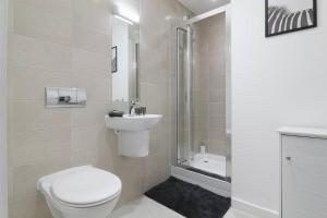 Baño blanco con aseo y lavamanos en Stylish modern home in Sheffield en Sheffield