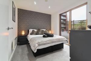 a bedroom with a bed and a large window at Stylish modern home in Sheffield in Sheffield