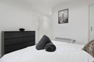 a bedroom with a white bed with a black dresser at Stylish modern home in Sheffield in Sheffield