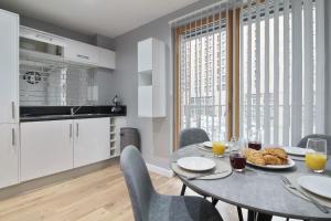 una cocina con mesa y sillas con comida. en Stylish modern home in Sheffield en Sheffield