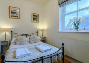 a bedroom with a bed with two pillows and a window at The Mews in Southwold