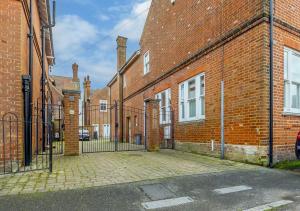 a gate in a brick building next to a street at The Mews in Southwold