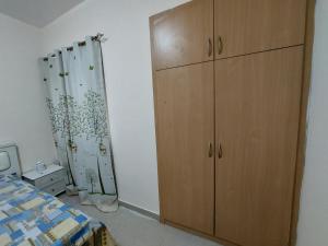 a bedroom with a dresser and a bed and a closet at VACATION HOME STAY AT SHRJAH DUBAI BORDER By mauon tourism in Sharjah