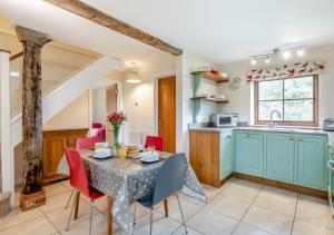 a kitchen and dining room with a table and chairs at Plough Cottage in Yoxford