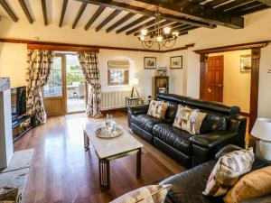 a living room with a leather couch and a table at Winding Wheel Cottage in Blythe