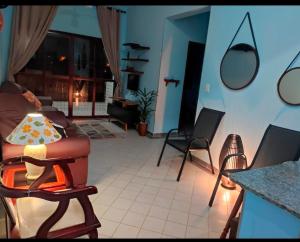 uma sala de estar com um sofá e cadeiras em Ap beira-mar com wi-fi e garagem em Mongaguá