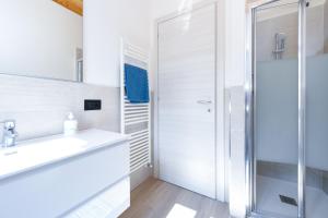 a white bathroom with a sink and a shower at Casa Contrada in Gargnano +27 photos