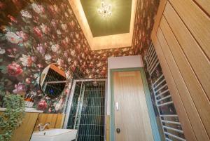 The Rose Nobel - 1 Bed Studio Apartment in Bristol by Mint Stays في بريستول: حمام به ورق جدران زجاجي ومغسلة ومرآة