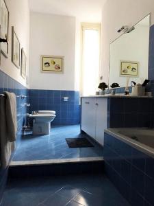 La salle de bains bleue est pourvue d'une baignoire et de toilettes. dans l'établissement B&B Genova Centro, à Gênes