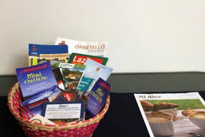 a basket filled with food and books on a table at Delizioso appartamento a Capalbio con vista in Capalbio