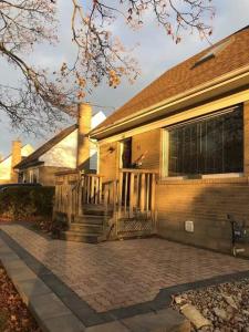 a house with a porch and stairs in front of it at Home from Home! in Brampton