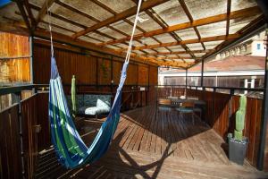 a porch with a hammock and a table in a room at La Casa Del Puerto, Hostal cultural, Cerro Alegre in Valparaíso +195 photos