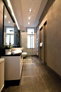 La salle de bains est pourvue de toilettes, d'un lavabo et d'un miroir. dans l'établissement Prague Elite Residences - Parizska street apartment 150 m2, à Prague
