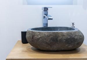 a stone sink with a faucet on a counter at Le Cinq Bis : centre-ville*proche gare*parking in Vesoul