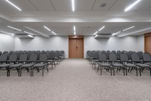 an empty room with rows of chairs in it at K-Platz Hotel in São José