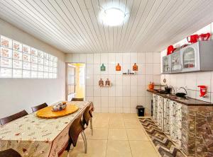 a large kitchen with a table and a counter at Otima casa com praia particular em Camacari BA in Camaçari