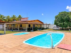 a large swimming pool in front of a house at Otima casa com praia particular em Camacari BA in Camaçari