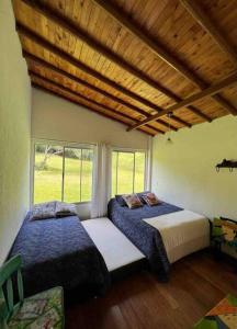 um quarto com 2 camas e uma janela em Casa de Campo Piedras Blancas em Medellín