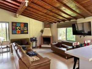 uma sala de estar com sofás, uma televisão e uma lareira em Casa de Campo Piedras Blancas em Medellín
