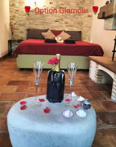 ピュジェ・シュル・アルジャンにあるFéerie Loveのワイングラス2杯とボトル1本付きのテーブル
