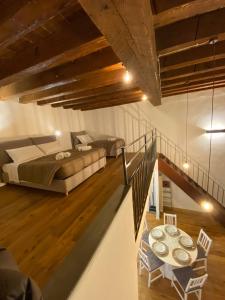a bedroom with two beds and a table and a staircase at signoria flat 5* centro storico in Florence