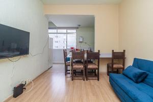 a living room with a blue couch and a dining room table at AP de frente p/ aquário e praia na ponta da praia in Santos