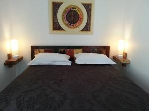 1 Schlafzimmer mit 2 Betten und 2 Leuchten an der Wand in der Unterkunft PAPAYE VERTE habitation CALISSA in Bouillante