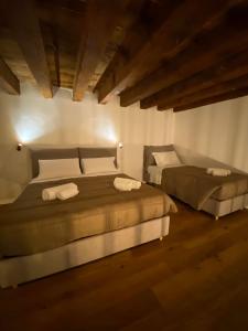 two beds in a room with wooden floors at signoria flat 5* centro storico in Florence