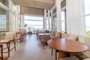 un ristorante con tavoli e sedie e grandi finestre di Studio moderno em condomínio de luxo pé na areia a Santos Altre 35 foto