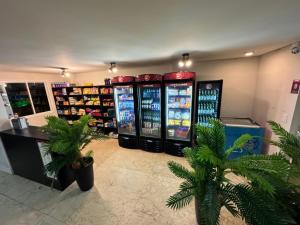 una tienda con dos máquinas expendedoras en una sala con palmeras en Vg Fun - TOP 03 acomodações no melhor da praia do futuro, FRENTE MAR! en Fortaleza