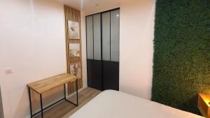 a room with a bed and a green wall at Le Cinq Bis : centre-ville*proche gare*parking in Vesoul