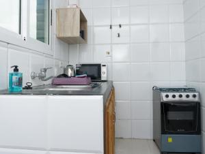 uma cozinha com um lavatório e um fogão em Résidence Céline em Libreville
