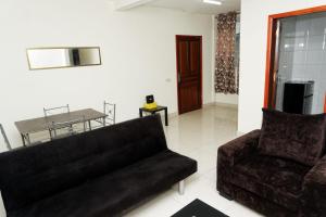 uma sala de estar com um sofá e uma mesa em Résidence Céline em Libreville