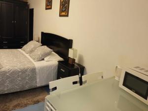 um quarto com uma cama e uma televisão numa mesa em My Colombo Place em Lisboa