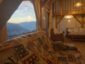 een woonkamer met een bank en een groot raam bij Chalet des Laix in La Rosière +11 foto's