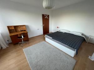 a bedroom with a bed and a dresser and a desk at Helle Wohnung mit großem Balkon in Oberreute