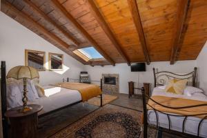 two beds in a room with wooden ceilings at Archontiko Fiamegou Hotel&Spa in Synikia Mesi Trikalon