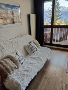 a bed with two pillows on it in a room at Super Sauze charmant studio en bas des pistes in Enchastrayes