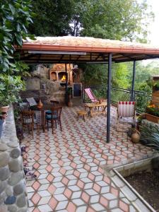 un patio con mesa y sillas bajo un pabellón en Sun Guest House, en Kutaisi