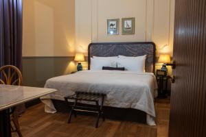 a bedroom with a bed and a table and two lamps at Communal Hotel Kutaisi in Kutaisi