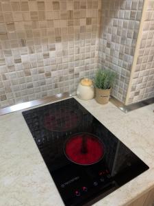 a black stove with a red burner in a kitchen at Ridi's Comfort Apartment in Shkodër +39 photos