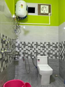 łazienka z toaletą i zieloną ścianą w obiekcie Kalden Homestay w mieście Dirang Dzong