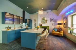 a kitchen with blue cabinets and a fireplace at The Royal Mint - 2 Bedroom Apartment in Central Bristol by Mint Stays in Bristol