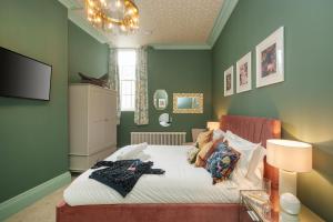 a bedroom with a bed with green walls at The Royal Mint - 2 Bedroom Apartment in Central Bristol by Mint Stays in Bristol