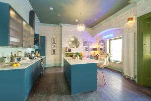 a kitchen with blue and green cabinets and a window at The Royal Mint - 2 Bedroom Apartment in Central Bristol by Mint Stays in Bristol