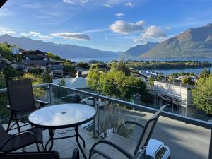 a balcony with a table and chairs and a view of a lake at Rangatira at 13 Poole lane in Queenstown